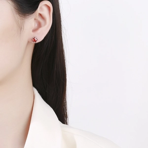 Gros plan du clou d'oreille étoile en argent 925 avec zircon rouge sur l'oreille