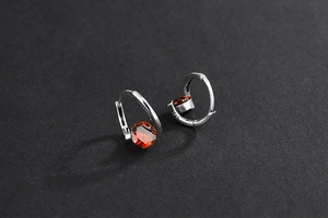 Detail of S925 sterling silver hoop earrings with brilliant red round zircon stones