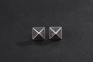 Detailed shot of retro silver pyramid earrings with colorful inlaid zircon stones