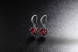 Detail of vintage silver drop earrings with spherical red faceted crystal clusters