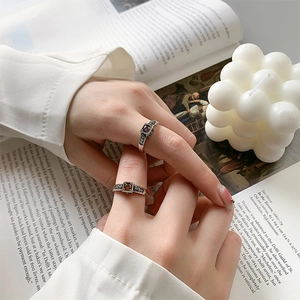 Vintage 925 silver rings with purple and red square stones on a retro open book