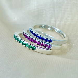 Close-up of three 925 sterling silver rings with blue, pink and green gemstones