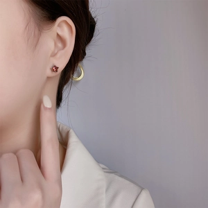 Boucles d'oreilles étoile en argent 925 avec cristal rouge portées par modèle