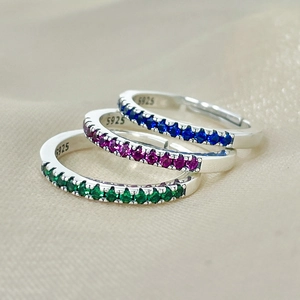 Detailed view of three stackable 925 sterling silver rings with colorful rainbow stones