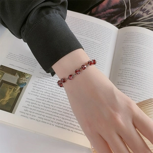 Élégant bracelet en argent massif S925 avec cristaux rouges sur le poignet d'une femme