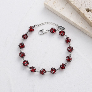 Détail du bracelet en zircone rouge avec cadre en argent et fermoir mousqueton