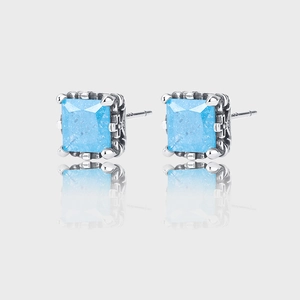Detailed macro view of square blue zircon earrings with vintage silver engraving