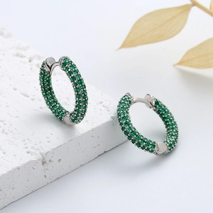 Détail de créoles en argent 925 avec pavage de pierres de zircone verte brillante
