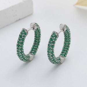 Vue macro de boucles d'oreilles créoles S925 argent avec pavé de zircons verts
