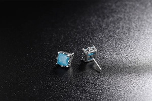 Macro shot of square blue zircon earrings with vintage silver filigree hollow patterns