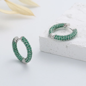 Vue détaillée des boucles d'oreilles en argent 925 serties de zircons verts avec poinçon S925