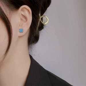Elegant square blue glitter earrings with silver edges worn by a female model