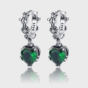 Macro shot of S925 silver earring featuring emerald heart stone and fleur-de-lis carving
