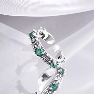 Macro shot of 925 sterling silver ring with three emerald green stones and carved details