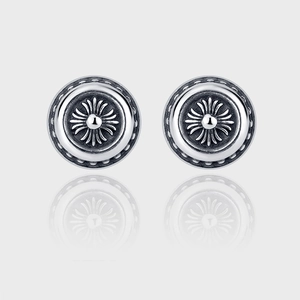 Detail of vintage 925 silver round stud earrings featuring carved punk floral cross motifs