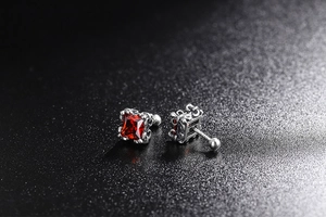 Macro detail of gothic 925 silver stud earrings with square red zircon and floral carvings