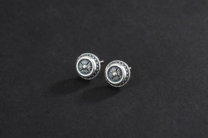Detail of 925 sterling silver round stud earrings with vintage cross flower engraving