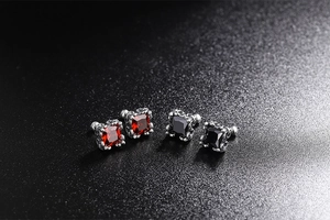Close-up of 925 silver gothic stud earrings with red and black square cut gemstones