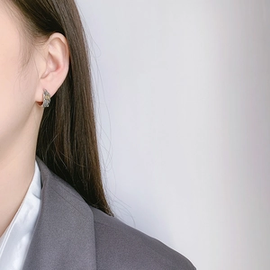 S925 Sterling Silver vintage feather hoop earring with gold accent worn by a model