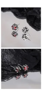 Macro detail of 925 silver stud earrings featuring ruby red stones in vintage claw settings