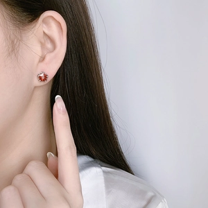 Star-shaped red zircon stud earrings with silver claw setting for a minimalist look
