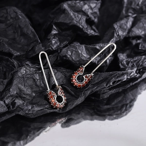Unique 925 sterling silver safety pin earrings with pave set orange gemstones on dark background