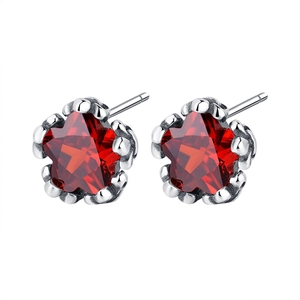 Star-shaped red zircon stud earrings in silver settings with a minimalist luxury design