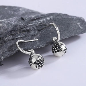 925 silver wish ball hook earrings with micro-set black stones on raw stone background