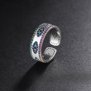 Macro shot of 925 sterling silver evil eye ring with colorful zircons on black background