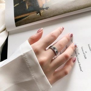 Detailed close-up of a vintage 925 silver wide ring with colorful stones on hand