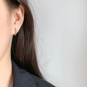 Textured 925 sterling silver geometric oval hoop earrings shown on a model ear