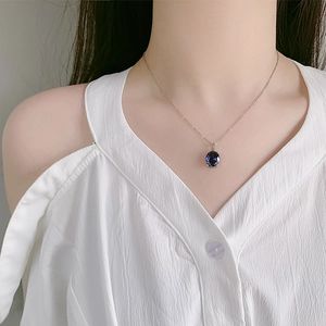 Elegant silver necklace with heart of ocean oval blue crystal pendant on female model
