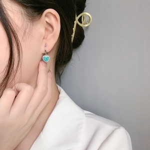 Boucles d'oreilles cœur élégantes avec pierre vert menthe et halo de zircons sur mannequin