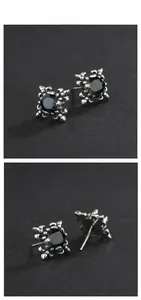 Macro detail of 925 sterling silver retro fleur-de-lis earrings with blue gemstones