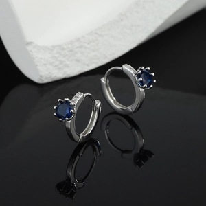 S925 Silber Creolen Herz des Ozeans mit blauen Zirkonia auf einem reflektierenden Hintergrund