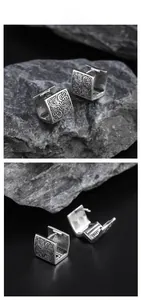 Macro view of vintage silver clip earring featuring relief auspicious cloud patterns
