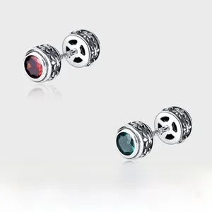 Gros plan de puces d'oreilles en argent 925 vintage avec gemmes rouges et vertes