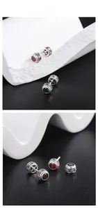 Détails macro de boucles d'oreilles en argent 925 avec zircons rouges et verts sertis