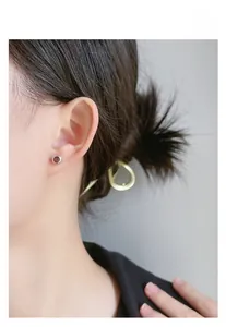 Gros plan sur un clou d'oreille en argent 925 avec pierre rouge sur l'oreille