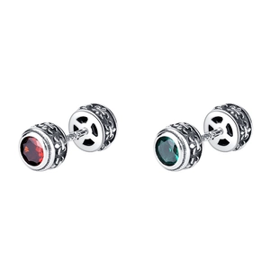 Détail macro de boucles d'oreilles en argent 925 avec gemmes rouges, vertes et gravures