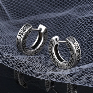 Dettaglio di orecchini a cerchio vintage in argento s925 con incisioni a fogliame