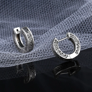 Dettaglio di orecchini a cerchio vintage in argento s925 con intricati motivi floreali neri