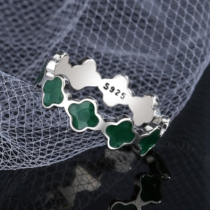 Bague élégante en argent sterling S925 avec trèfles verts sur une surface miroir noire