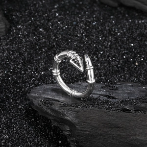 Retro 925 sterling silver arrow open ring with black crystals on a dark textured background