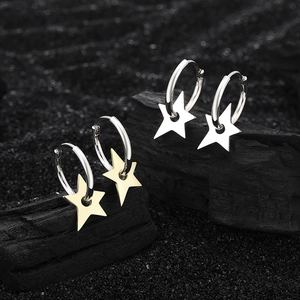 Polished silver and gold star hoop earrings displayed on aesthetic dark textured background