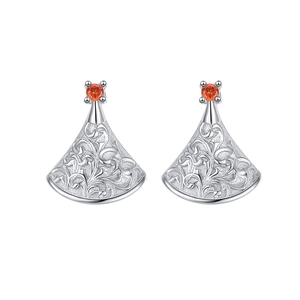 Silver fan-shaped drop earrings with floral engraving and red stone on white background