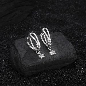 S925 sterling silver hoop earrings with four-pointed star pendants on dark stone background