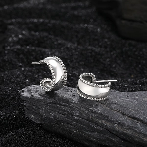 Polished S925 sterling silver C-shaped hoop earrings with beaded edges on dark stone