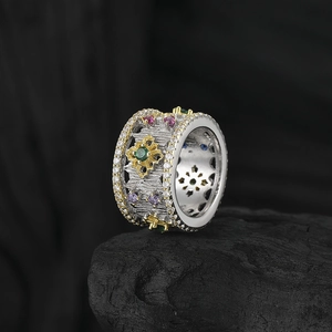 Vintage hollow wide band ring with colorful zircon stones on dark stone background
