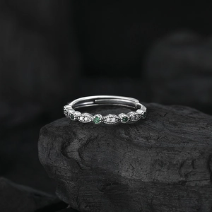 Bague en argent S925 avec émeraudes et pavé sur fond de roche noire élégant